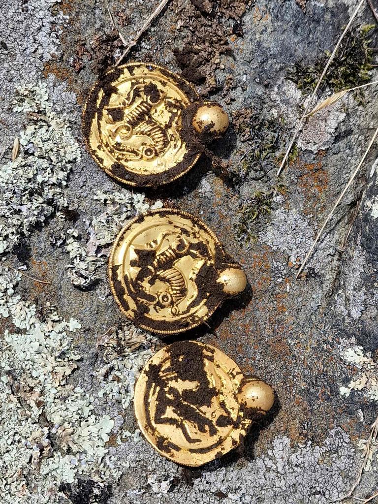Mr Bore found these coin-like gold pendants. (Photo by Erlend BORE / NTB / AFP)