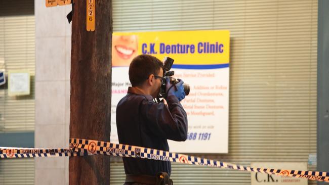 A police photographer documents the scene. Picture: Damian Hoffman