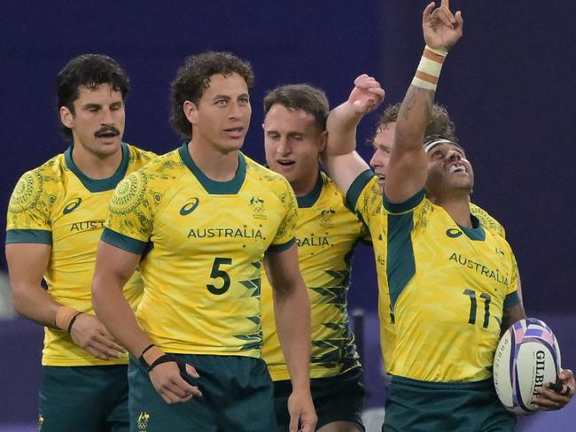 Australia players celebrate winning the men's quarter final rugby sevens match between Australia and USA during the Paris 2024 Olympic Games at the Stade de France in Saint-Denis on July 25, 2024. (Photo by CARL DE SOUZA / AFP)