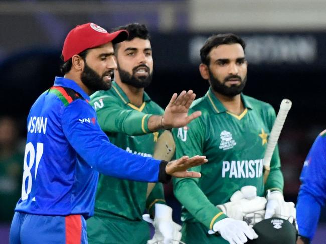 Security personnel detain a spectator (C) who entered the ground at the end of the ICC menâs Twenty20 World Cup cricket match between Afghanistan and Pakistan at the Dubai International Cricket Stadium in Dubai on October 29, 2021. (Photo by Aamir QURESHI / AFP)