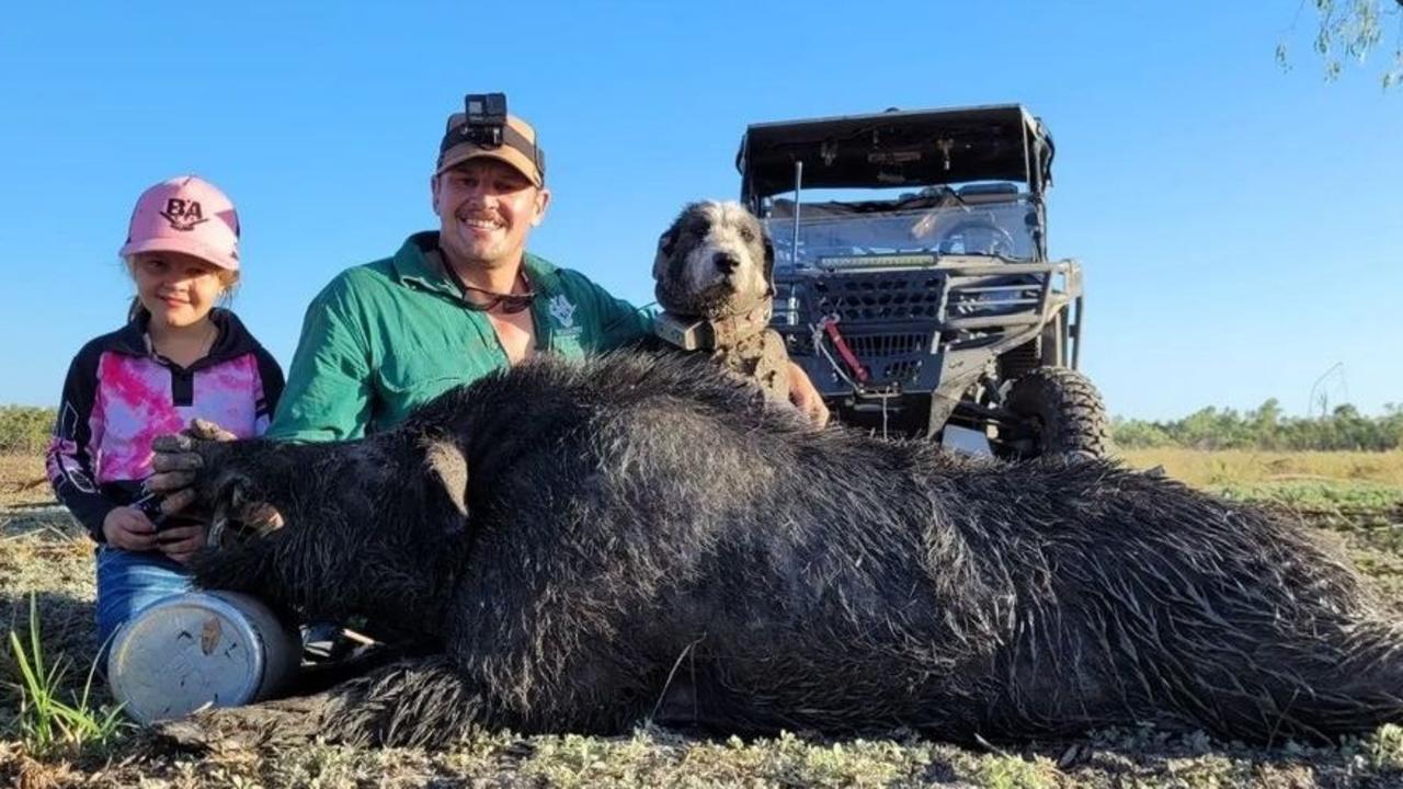 Daniel Folpp sits with his daughter over a pig they have caught and killed. Boaring Australia.