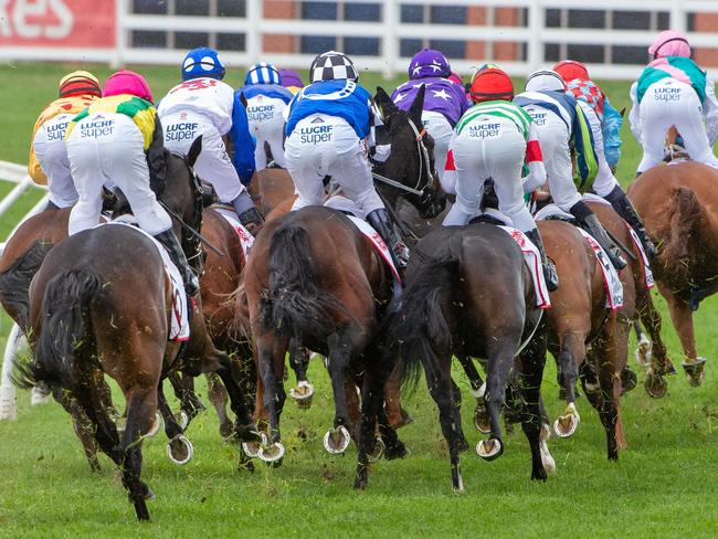 Mer De Glace (red cap) sits at the rear as the field leaves the home straight on the first occasion. Picture Jay Town