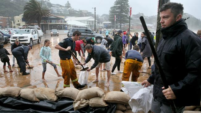 Surf club members, locals and fire fighters laid sandbags to protect the Avoca Beach Surf Club and cafe, as the storm swell threatened to flood them on Sunday. Picture: Troy Snook