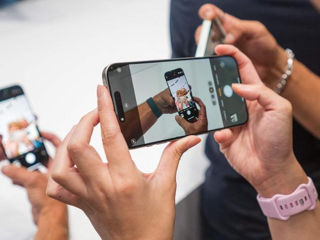 A woman takes a video of the new iPhone 16 Pro after Apple's "It's Glowtime" event in Cupertino, California, September 9, 2024. Apple on Monday announced a new iPhone built for generative artificial intelligence as it seeks to boost sales and show it is keeping up in the technology race. (Photo by Nic Coury / AFP)