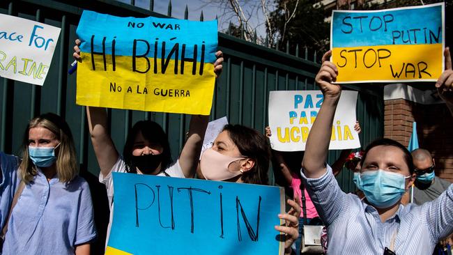 Ukrainian citizens hold posters during a protest in support of Ukraine in front of the Russian Embassy in Santiago, on February 24, 2022. (Photo by MARTIN BERNETTI / AFP)