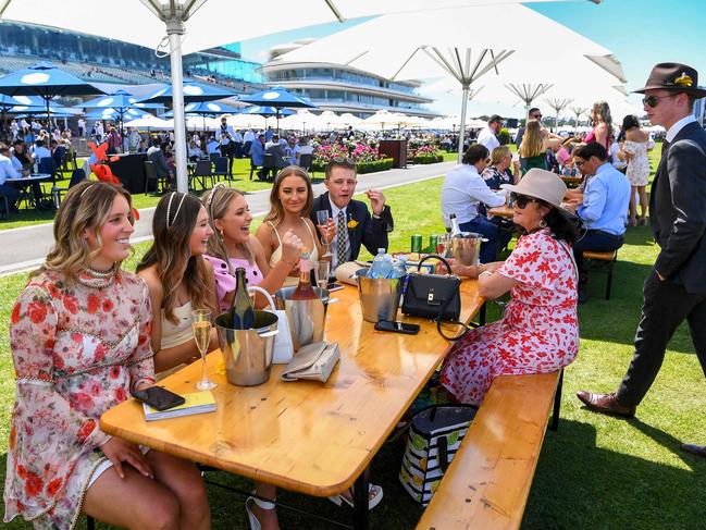 Punters enjoy the day while seated at trackside tables. Picture: William WEST/AFP