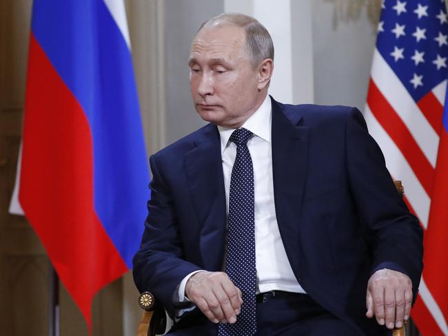 Russian President Vladimir Putin listening as US President Donald Trump talks to reporters.