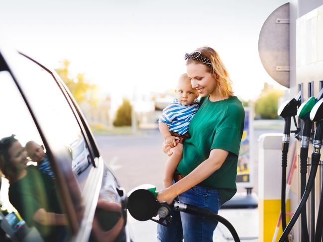 ESCAPE:  Young mother with baby boy at the petrol station refuelling the car. Picture: Istock