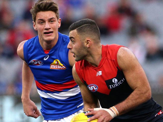 Christian Salem of the Demons (right) runs forward under pressure from Patrick Lipinski of the Bulldogs during the Round 17 AFL match between the Melbourne Demons and the Western Bulldogs at the MCG in Melbourne, Saturday, July 14, 2018. (AAP Image/Hamish Blair) NO ARCHIVING, EDITORIAL USE ONLY