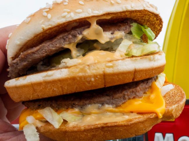 (FILES) In this file photo taken on August 10, 2015 a McDonald's Big Mac, their signature sandwich is held up near the golden arches at a McDonalds's, in Centreville, Virginia. - McDonald's, home of the Big Mac, reported a dip in third-quarter profit on October 23, 2018, but notched comparable sales growth in key regions, including Britain, France and Japan. Net income at the fast-food giant fell to $1.6 billion, a drop of 13.1 percent from the same period of the prior year. But the 2017 quarter was boosted by about $850 million from the sale of businesses in China and Hong Kong. (Photo by Paul J. RICHARDS / AFP)