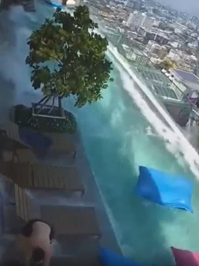One swimmer is nearly swept off the rooftop as giant waves crash across the deck