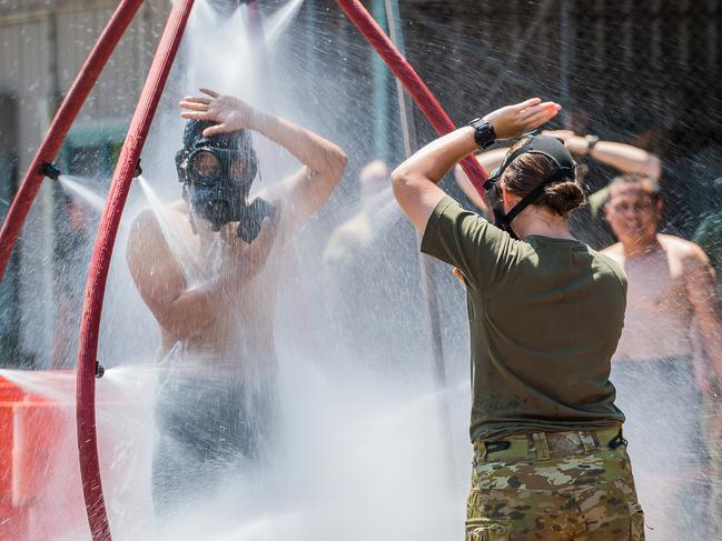 An Australian Army soldier directs a member from Indonesian Army through the decontamination shower during the Chemical Biological Radiological Nuclear (CBRN) training activity at the Regiment's out training facility in October 2017. Picture: Department of Defence