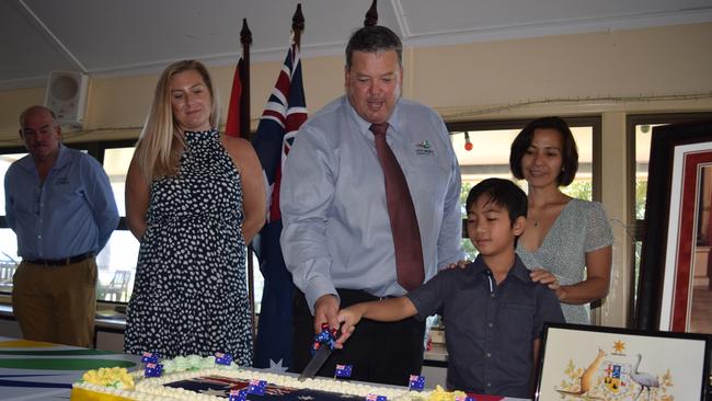 Mayor Andrew Willcox (centre) cuts the cake with new Australian citizens (from left) Hannah Griffiths and John, 10, and Venus Bishop at the Australia Day Citizenship Ceremony in Bowen. Photo: Elyse Wurm