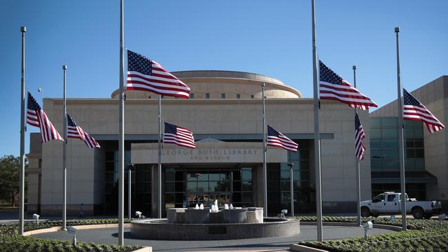 Flags fly at half-mast in front of the George H.W. Bush Presidential Library Centre on the campus of Texas A&amp;M University on December 2, 2018 in College Station, Texas.