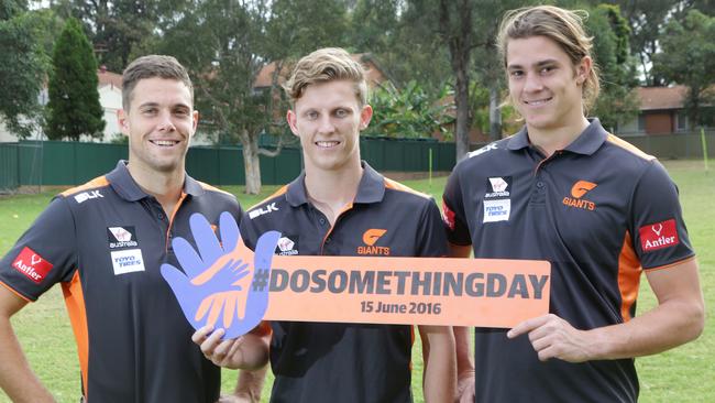 GWS Giants players Josh Kelly, Lachie Whitfield, Jack Steele pose with a DoSomething Day sign at Bankstown West Public School. Picture: Timothy Clapin