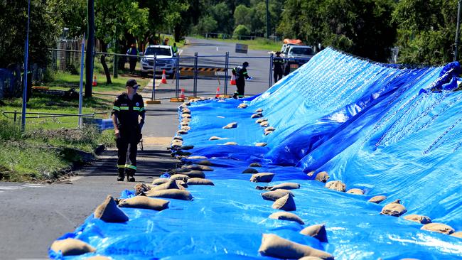 Emergency services personnel check on a temporary levee built to save houses in Berserker, Rockhampton. Picture: Tim Marsden