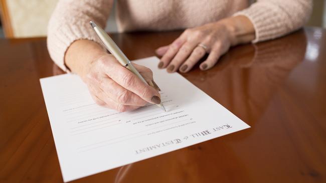 A woman signs her last will and testament.