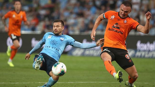 Kosta Barbarouses of Sydney FC, left, and Roar captain Tom Aldred challenge for the ball at Netstrata Jubilee Stadium