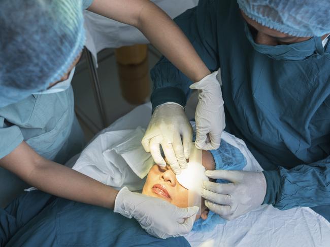 Nurse covering eye of patient by medical plasterPicture: istock