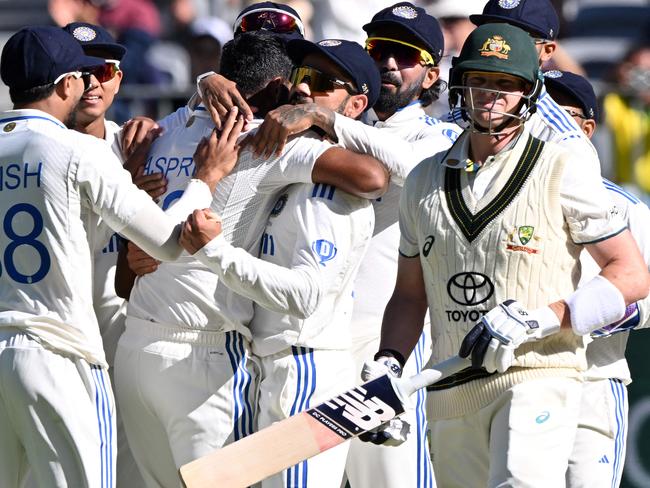 India's Virat Kohli gives a hug to paceman Jasprit Bumrah after taking the wicket of Steve Smith. Saeed Khan /AFP