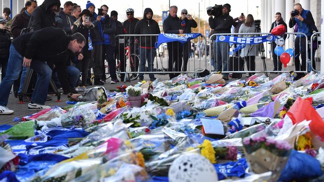 A man adds flowers to a growing pile of tributes outside Leicester City Football Club's King Power Stadium. Picture: AFP