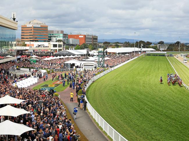 The sun emerges as the field makes the famous dash to post for the first time. Picture: Mark Stewart