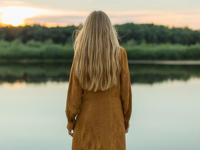 Rear view. Blonde woman in yellow dress