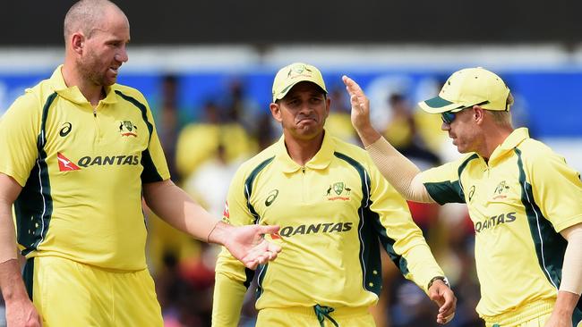 Australian cricketer John Hastings (L) celebrates with teammates Usman Khwaja and David Warner. Picture: AFP