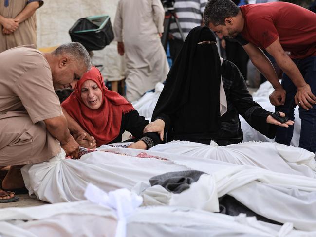 A woman mourns over the body of a relative killed in an Israeli strike, in front of the morgue of the Al-Aqsa hospital in Deir Balah in the central Gaza Strip. Picture: AFP