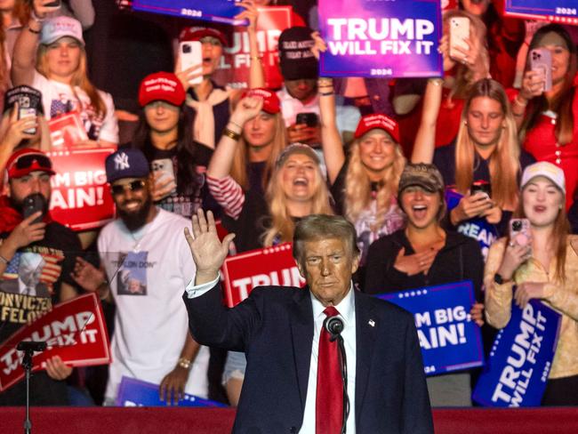 TOPSHOT - Former US President and Republican presidential candidate Donald Trump waves at supporters during a campaign rally at First Horizon Coliseum in Greensboro, North Carolina, on November 2, 2024. (Photo by CHRISTIAN MONTERROSA / AFP)