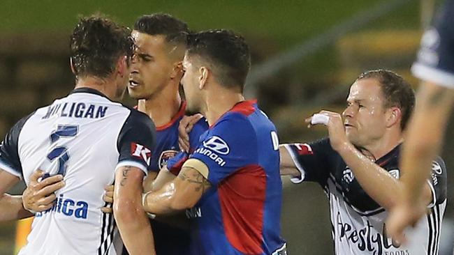 Melbourne Victory’s Mark Milligan lunges at Newcastle’s Daniel Georgevski and is sent off.