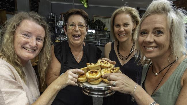 Seasons Cafe owner, in Mt Beauty Deb  Lembke serving a customer Caroline, Lee and Monika in her cafe. Picture: Tony Gough