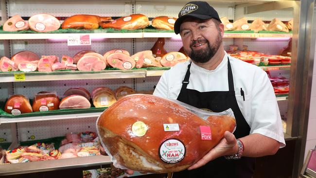 Butcher Steve Hancock with a huge leg of ham which is expected to get a lot more expensive as Christmas nears. Picture: Brett Costello