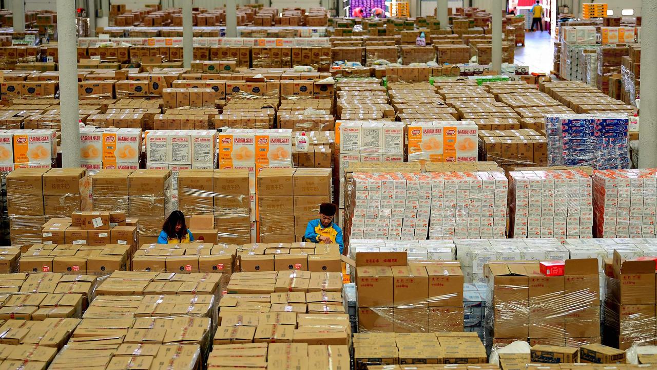 Employees sort items at a storage facility in Shenyang. Picture: STR/AFP