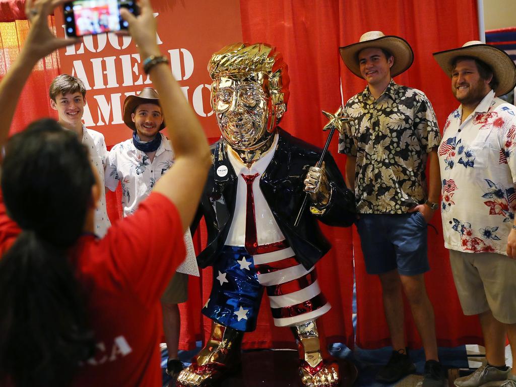 People take a picture with former President Donald Trump's statue. Picture: AFP