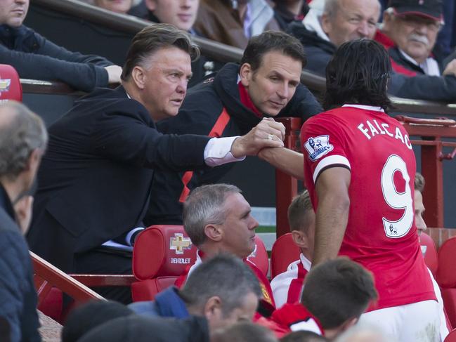 Manchester United's Radamel Falcao, center right, shakes hands with manager Louis van Gaal after being substituted during his team's 2-1 English Premier League soccer match win against Everton, at Old Trafford Stadium, Manchester, England, Sunday Oct. 5, 2014. (AP Photo/Jon Super)