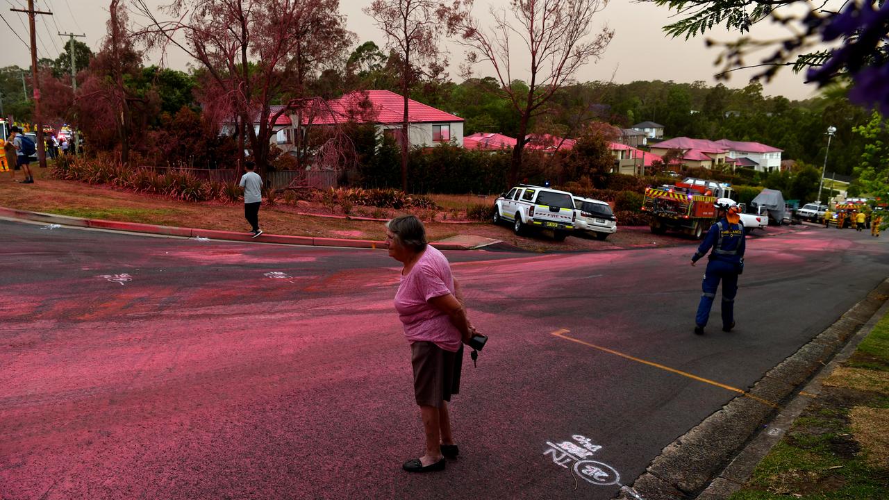 A resident at South Turramurra, in Sydney, walks among the pink fire-retardant that was dropped on Tuesday. Picture: Getty Images