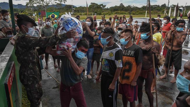 Indigenous Ye'kuana and Yanomami ethnic groups receive food supplies at the 5th Special Frontier Platoon in Auari, Roraima state, Brazil, on June 30, 2020, amid the novel coronavirus COVID-19 pandemic.