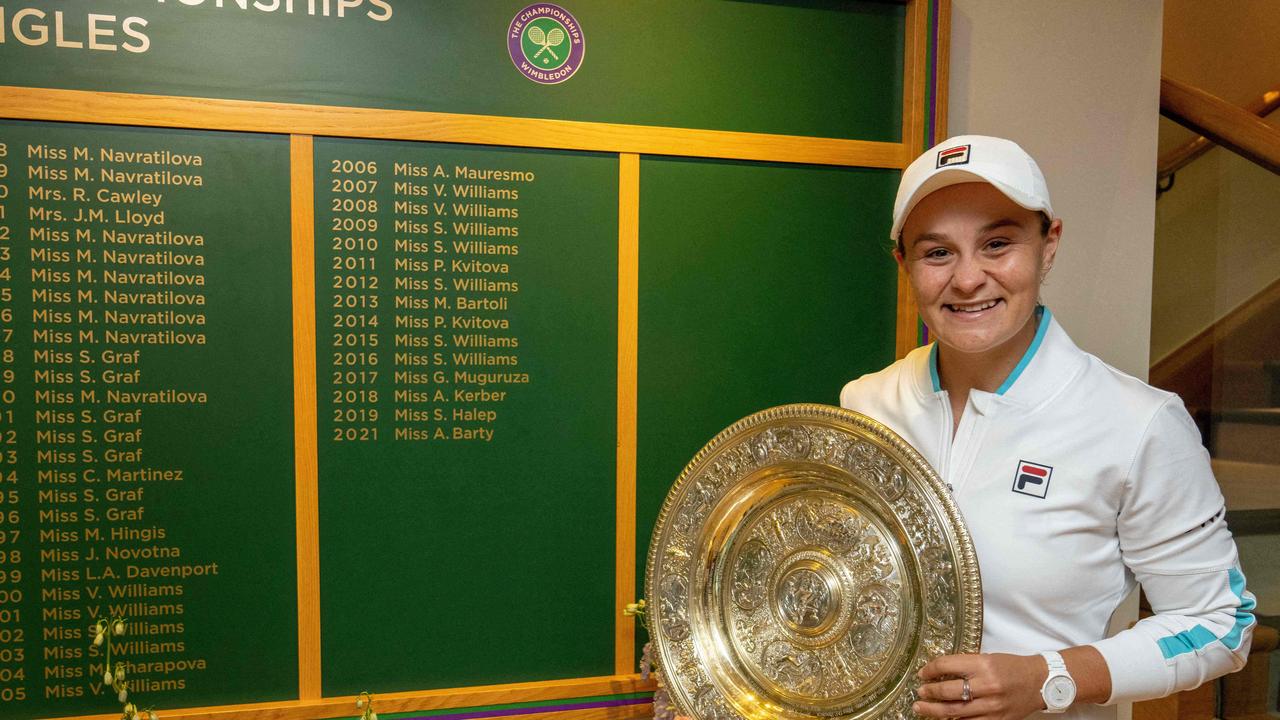 Australia's Ashleigh Barty poses with the winner's Venus Rosewater Dish trophy in front of the Ladies' Singles Winner's Board on the after winning her women's singles match against Czech Republic's Karolina Pliskova on the twelfth day of the 2021 Wimbledon Championships at The All England Tennis Club in Wimbledon, southwest London, on July 10, 2021. (Photo by AELTC/Thomas Lovelock / POOL / AFP) / RESTRICTED TO EDITORIAL USE