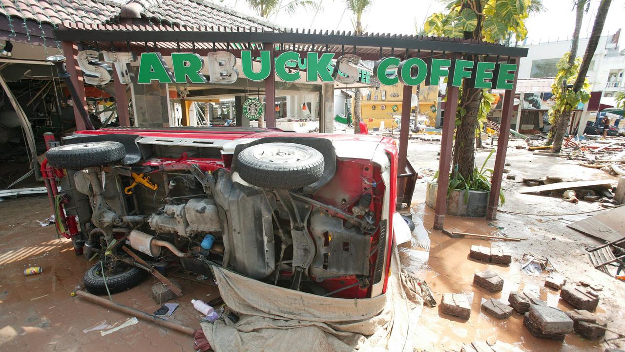 A car lies on its side in front of a Starbucks Coffee shop after the tsunami hit Patong beach in Phuket. Picture: AP PicKarim/Khamzin