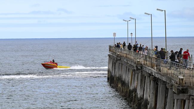 Police and surf rescue search the area for a shark after a man swimming was attacked at Port Noarlunga Beach on Thursday. Picture: Mark Brake