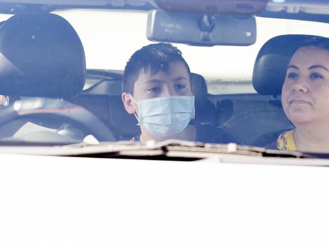 Student Justin Robinson waits with his family to get COVID tested at the Parklands Christian College in Park Ridge. Picture: NCA NewsWire / Jono Searle