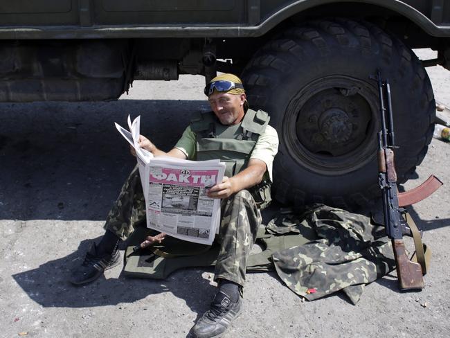 A Ukrainian soldier reads a newspaper at a checkpoint in the eastern city of Debaltseve. Picture: Anatolii Stepanov