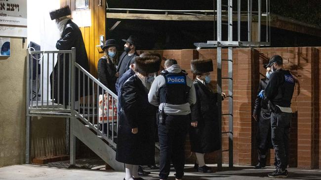 People outside the synagogue after police swooped. Picture: Mark Stewart