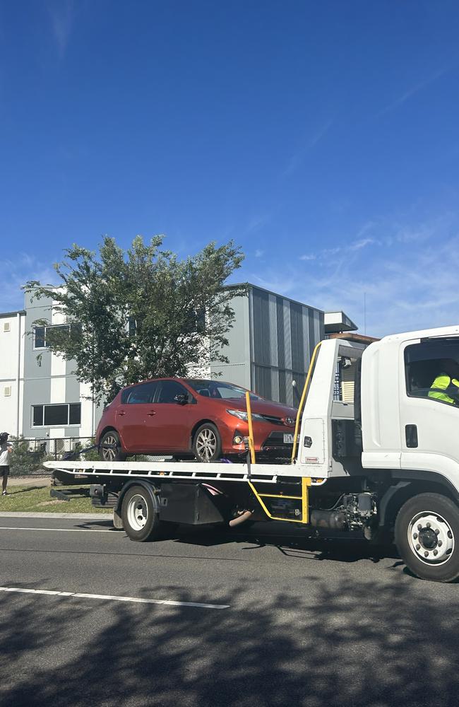 An orange Toyota is towed from the scene on Saturday morning. Picture: Georgie Kibel