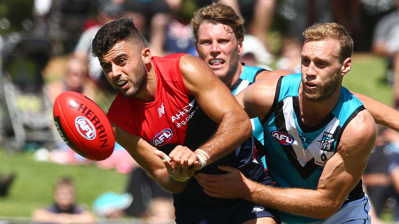 AFL NAB CHALLENGE - Port Adelaide v Melbourne at Playford Oval, Elizabeth. Watts gets his handpass away from Jack Hombsch. Photo Sarah Reed.