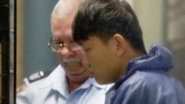 Shuo Dong is led to a prison van at Burwood Local Court in 2018. Picture: Chris Pavlich