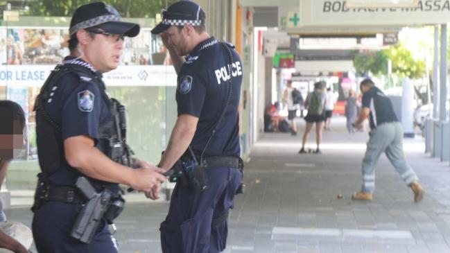 Police confiscate alcohol and move people on from the Shields St pedestrian mall in the Cairns CBD on Friday. Picture: Peter Carruthers