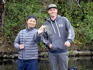 SMALL BEGINNINGS: Zaiyu Hasegawa, with bass fishing champion Braden Schuch, started small with this Australian bass, which he quickly returned to the water. It was the first of the species, or any Australian native fish, he had ever caught. Picture: Arthur Gorrie