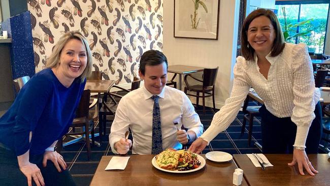 Bonney MP Sam O'Connor is served a chicken parmigiana by LNP leader Deb Frecklington at the Arundel Tavern as Deb Frugtniet watches on.